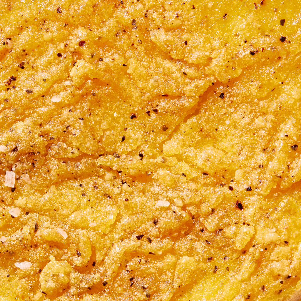 Close-up of a yellow textured surface with black specks